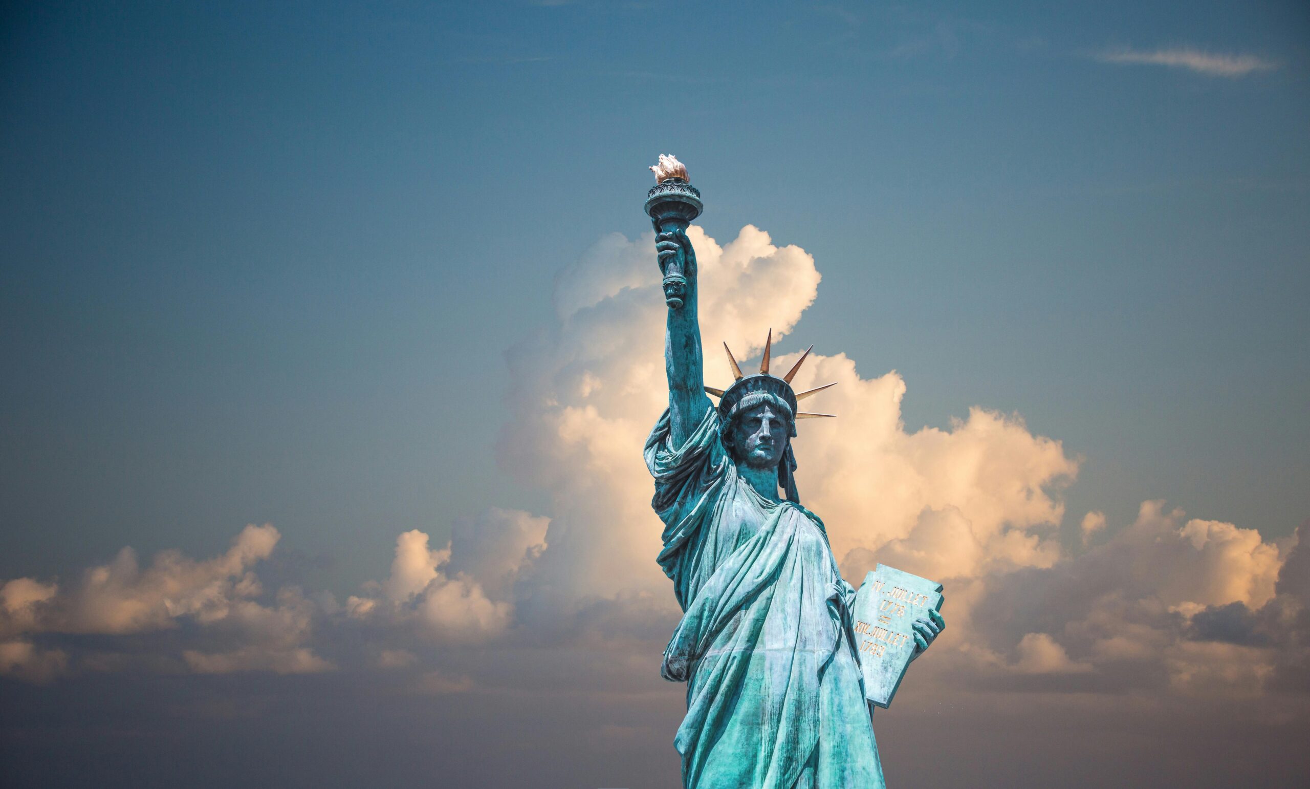 Statue of Liberty in New York with clouds in the background symbolizing ongoing discussion on psilocybin reform and retreat possibilities in 2025
